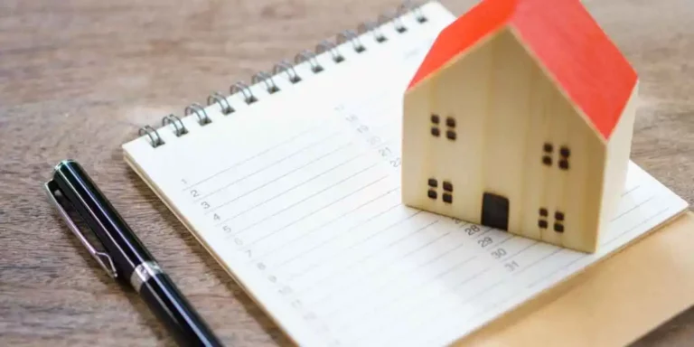 pen, paper and home dummy to show the home maintenance checklist