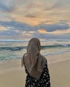 A girl in hijaab to seeing the ocean on the shore